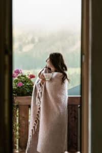Frau auf Terrasse mit Blick auf die Berge
