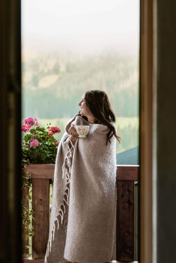 Frau auf Terrasse mit Blick auf die Berge